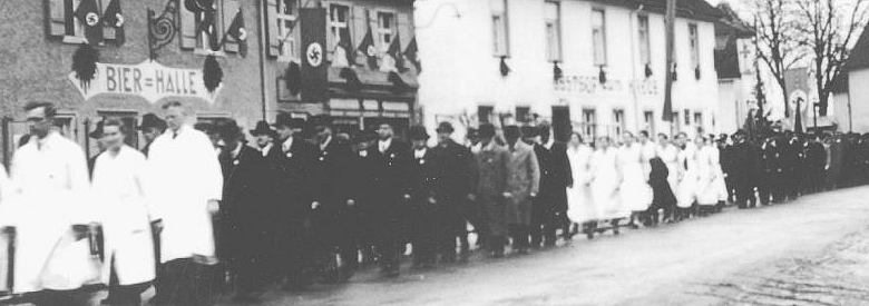 Das Bild zeigt einen Umzug des Anstaltspersonals von Zwiefalten zum 1. Mai 1938.